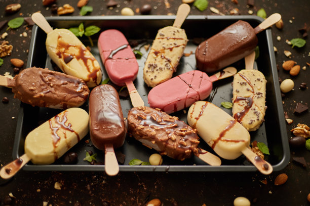 各种冰棒冰淇淋，白巧克力和黑巧克力，杏仁，锈色背景图片下载