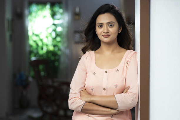 一个年轻的女人在电话聊天，站在门口附近:-库存照片图片下载