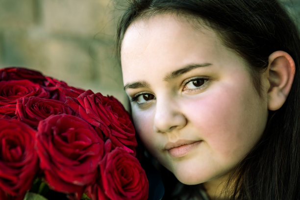 12岁的女孩拿着一束红玫瑰图片下载