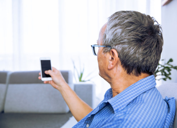 成熟的男人在家里使用手机图片下载