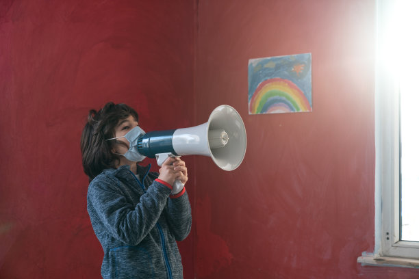 学童戴面罩，用扩音器说话图片下载