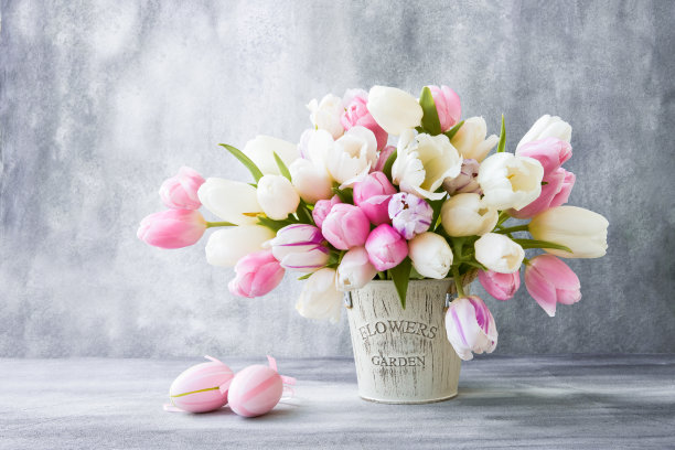 复活节装饰和花瓶中的郁金香花束在灰色的背景上。图片下载