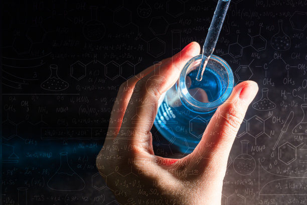 手握烧瓶与实验室玻璃器皿和试管在化学实验室的背景，科学实验室研究和发展的概念图片下载