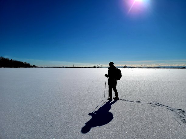 在冰雪覆盖的冰面上徒步旅行的人图片下载