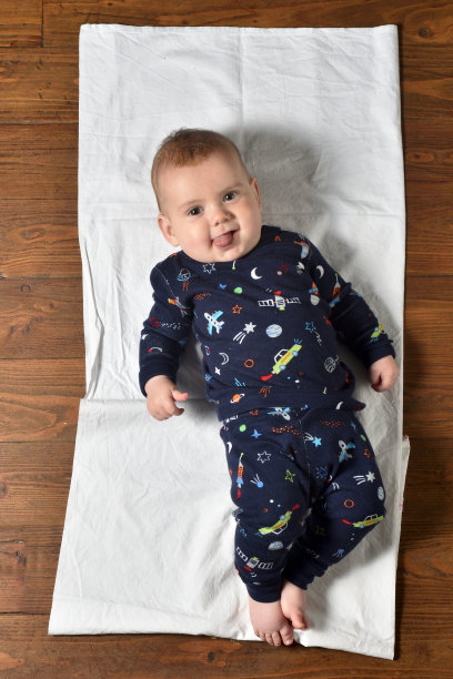 高角度的观点，一个婴儿在拼花地板上穿着睡衣图片下载