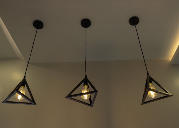 一个美丽的图片三个天花板灯固定装置与电灯泡发出柔和的金色光在一个家庭内部。图片下载