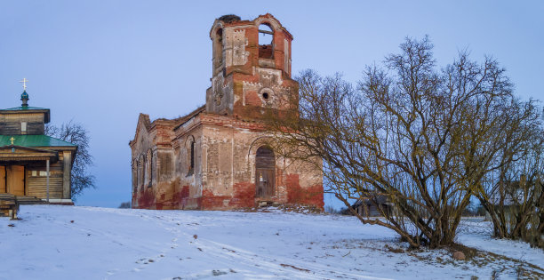 黄昏时分，古老的教堂废墟和现代木制教堂的全景。宗教的概念。图片下载