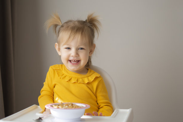 可爱的女孩在家用勺子吃健康食品。图片下载