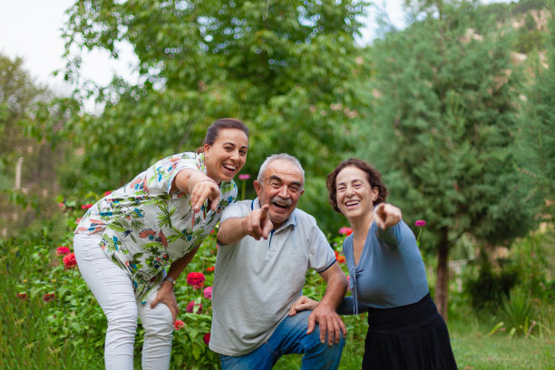 在绿意盎然的树丛中，一家人用食指指着一个地方图片下载