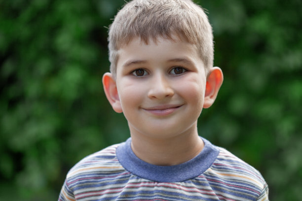 快乐男孩的肖像是在公园或户外微笑着享受领养的生活图片下载