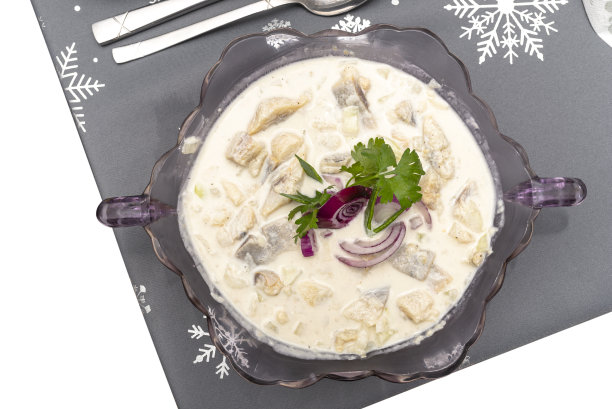 奶油生鲱鱼，放在波兰假日餐桌上的玻璃花瓶里，被孤立在白色的背景上，有一条剪影小径，俯视图。图片下载