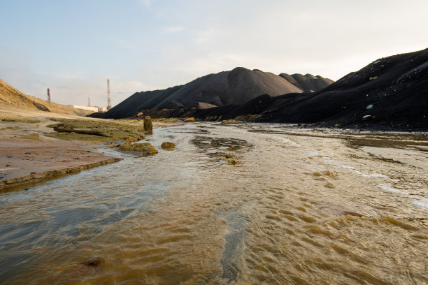荒凉的地区，河水污浊，土壤污染，群山环抱图片下载