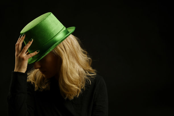 一个女人的脸被一顶绿色的帽子遮住的特写图片下载