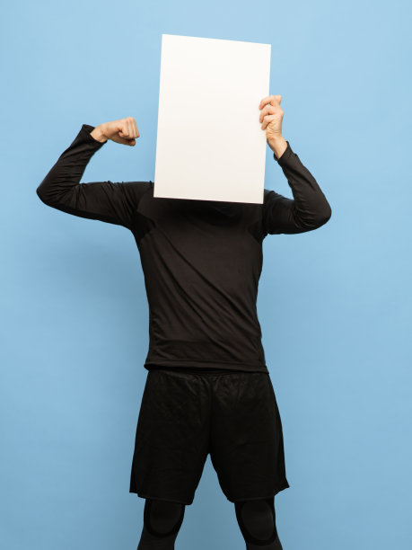 穿着黑色服装的年轻人与空白纸孤立在蓝色背景。图片下载