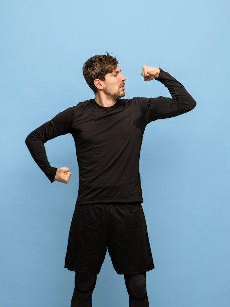 一幅运动白人男子的肖像，穿着黑色服装，孤立在蓝色背景上。图片下载