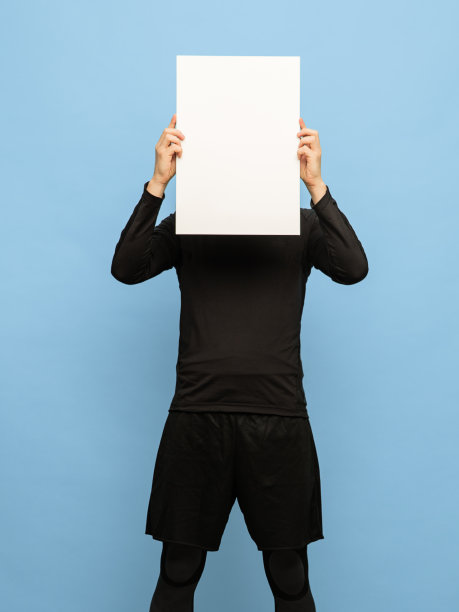 穿着黑色服装的年轻人与空白纸孤立在蓝色背景。图片下载