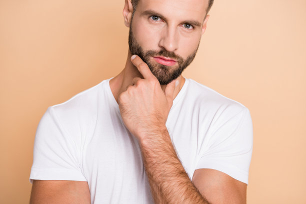 裁剪照片的年轻英俊的男人认真思考头脑风暴手触摸下巴孤立的米色背景图片下载