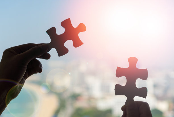 自闭症和自闭症，孩子把拼图拼在一起。孩子们的手，学生们拿着一块块的拼图，作为学校团队合作的象征。图片下载