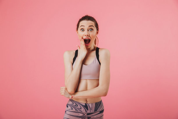 震惊快乐的女运动员抚摸着她的脸颊，看着相机图片下载