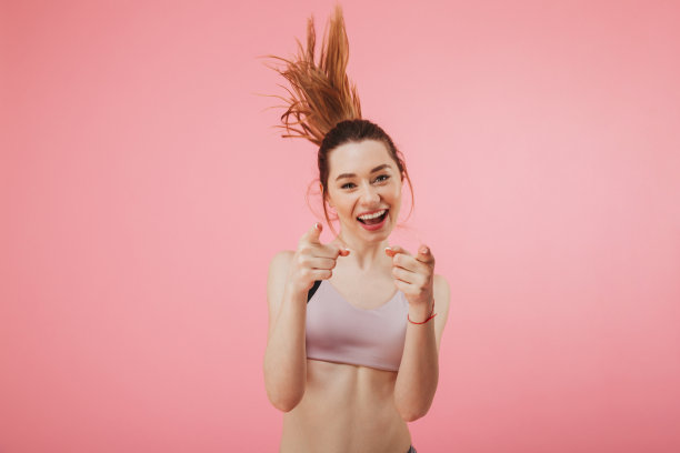 微笑的女运动员一边跑一边指着并看着摄像机图片下载