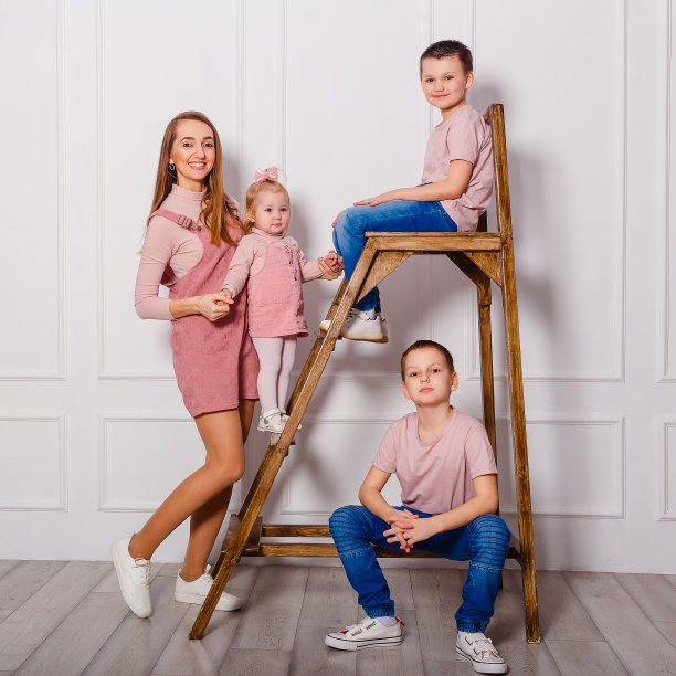 微笑的年轻妇女和三个孩子。母亲和孩子们快乐。母亲节图片下载