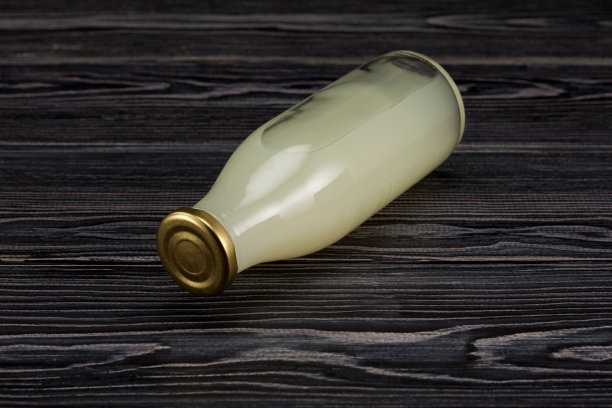 自制燕麦片淡啤酒。一瓶发酵饮料躺在深色的木质背景上图片下载