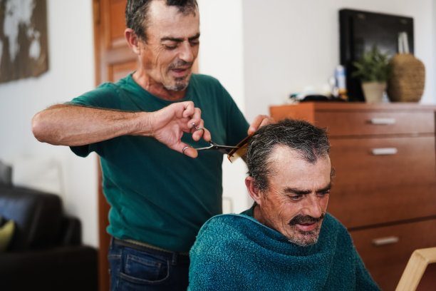 在冠状病毒封锁期间，双胞胎哥哥在家里剪头发-集中精力找对人图片下载