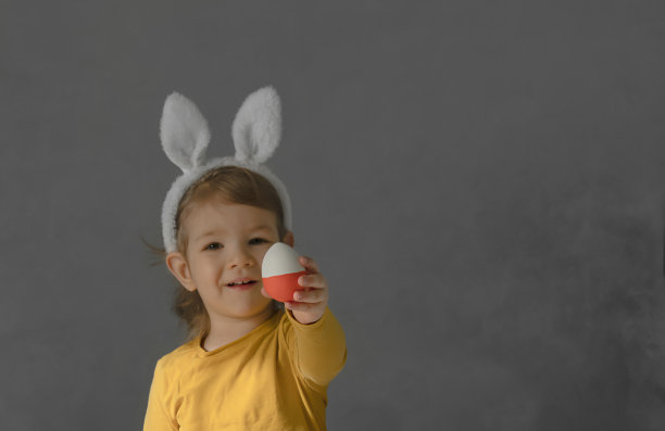 近距离的肖像可爱的宝宝兔子耳朵拿出复活节彩蛋股票照片图片下载
