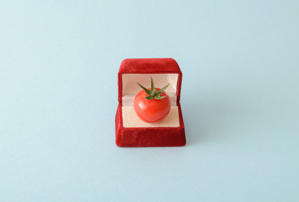 订婚戒指盒里的樱桃番茄。在奶油色的背景上。婚姻和订婚的概念。浪漫的生活方式的想法。简单的构图。图片下载