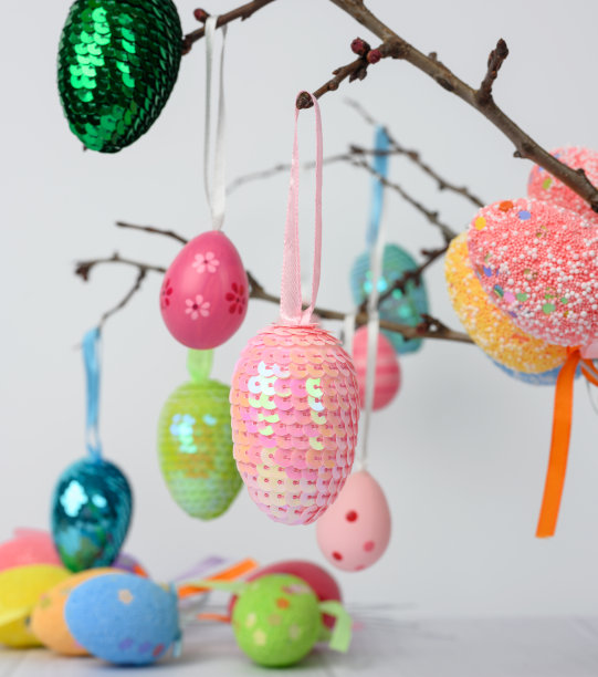 装饰复活节彩蛋挂在树枝上，白色的背景图片下载