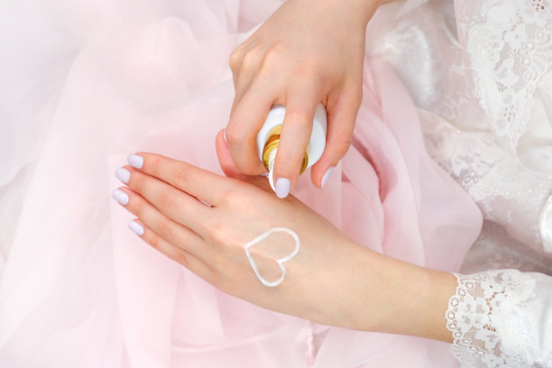 漂亮整洁的女性双手，手掌上涂着心形的奶油。图片下载