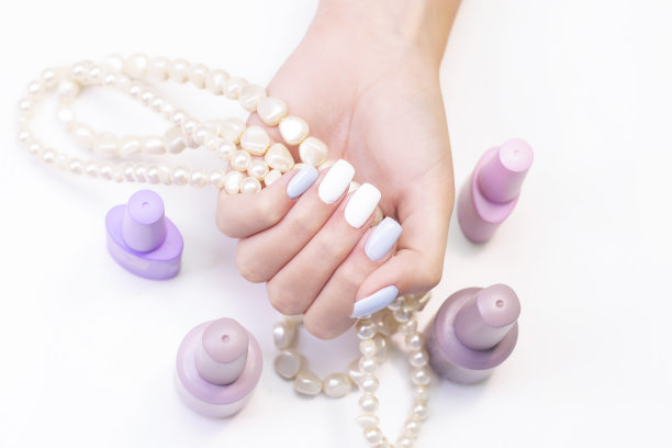 一个年轻女子的美丽的手在一个珠子的背景图片下载