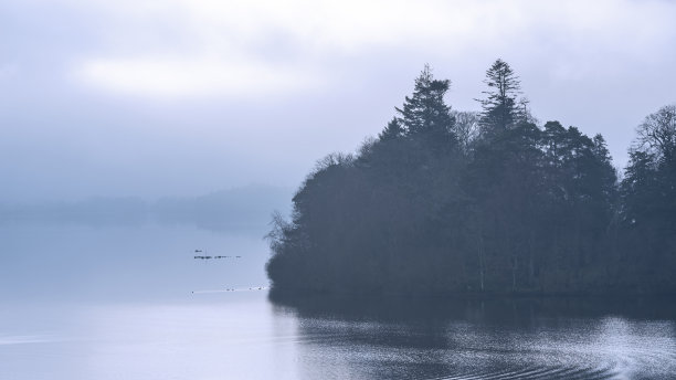 这是一幅引人注目的景观图片，从Derwentwater湖区望向Catbells雪山，浓雾在山谷中翻滚图片下载