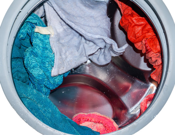 在洗衣机里旋转的滚筒上放着衣服。图片下载