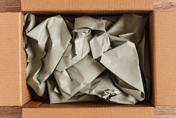 纸板箱里面有皱巴巴的纸，用来包装网上商店的商品，用可回收的原材料制成的环保包装图片下载