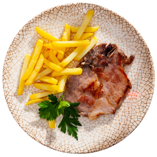 猪排和炸薯条放在盘子里。图片下载