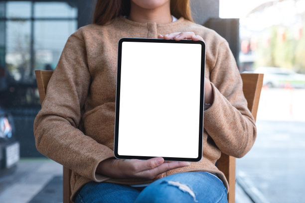 一名妇女拿着并展示着带有空白桌面屏幕的数字平板电脑图片下载