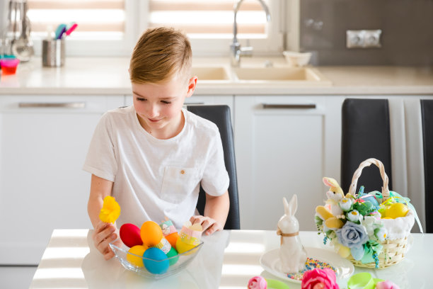 孩子们在画五颜六色的鸡蛋。男孩画并装饰复活节彩蛋。图片下载