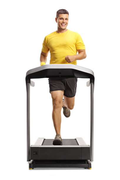 一个穿着运动服在跑步机上跑步的男人的全长肖像，看着镜头图片下载