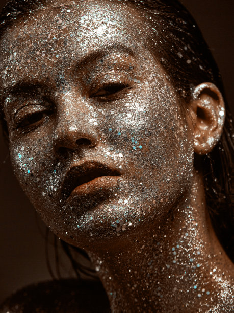 女性与银光闪闪的化妆，年轻女孩与皮肤在节日闪闪发光的身体艺术，近距离工作室肖像图片下载