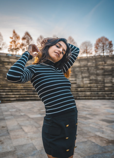 一个微笑的深色头发和条纹毛衣在照片拍摄图片下载