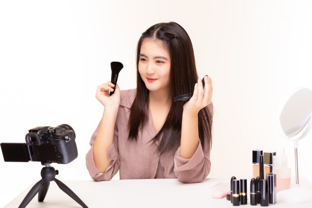 网红的美容师拿着化妆刷在她美丽的脸上展示粉底图片下载