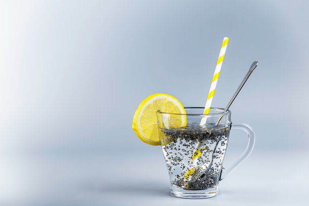 奇亚柠檬水在玻璃杯中与柠檬片，饮用吸管和勺子图片下载