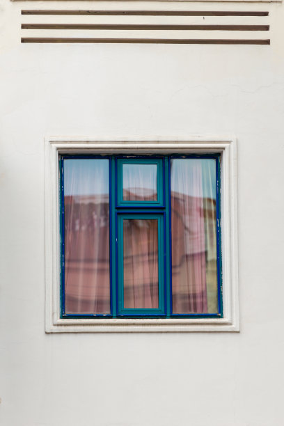 白色的墙和蓝色的窗户在框架的中心，建筑细节图片下载