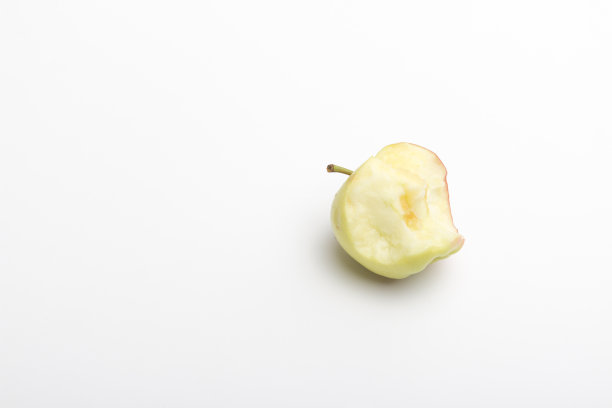 鲜红美味的咬苹果孤立在白色。一个苹果存根。图片下载