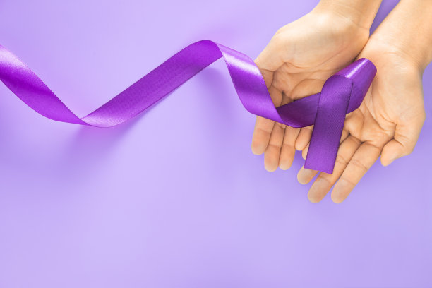 手握紫色或紫色丝带在紫色背景与复制空间。胰腺癌睾丸癌意识癌症幸存者平滑肌肉瘤世界癌症日。医疗保险的概念图片下载
