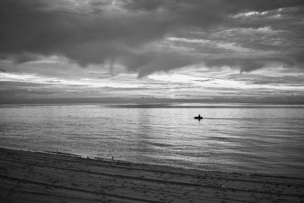 一个人乘着一只充气的船在海上航行。图片下载