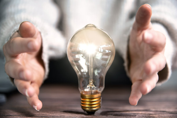 创意的概念，头脑风暴，商业想法，发光的灯泡和商人或学生的手图片下载