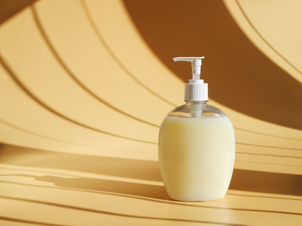 液体肥皂在分配器与咖啡阴影表面的奶油背景图片下载