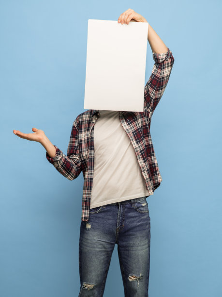 年轻人与空白纸关闭他的脸孤立在蓝色背景图片下载